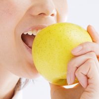 リンゴを噛もうとしている女性